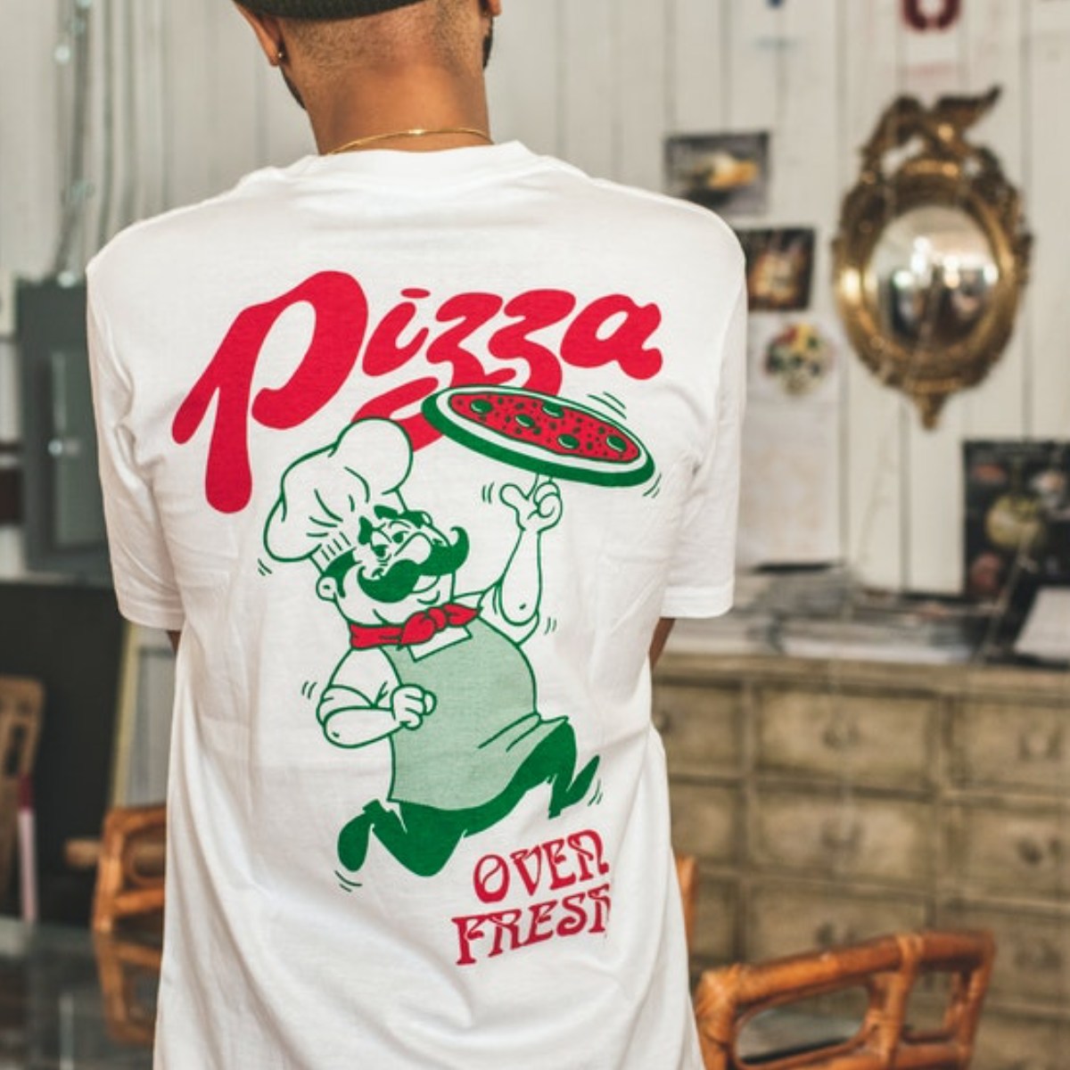 A person wearing a custom graphic shirt made for a pizza parlor